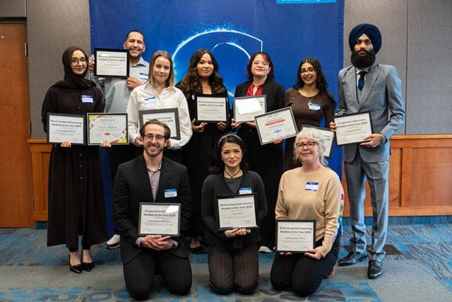 Ten Sheridan work-integrated learning student of the year award recipients hold their awards proudly while posing for a group photo