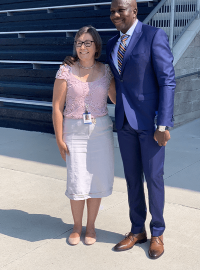 Christine Szustaczek stands beside Olympic champion sprinter - and former Sheridan student - Donovan Bailey during the filming of Sheridan's 2021 virtual Spirit Day event