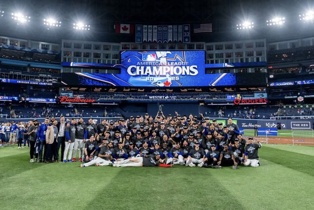 Members of the Toronto Blue Jays team and staff, including Sheridan Athletic Therapy student David Loiacono, gather for a photo on the Rogers Centre field after winning the American League Championship Series.