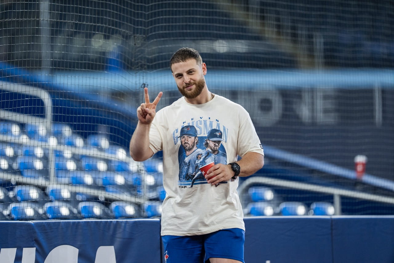 Athletic Therapy student David Loiacono is pictured on the field of the Rogers Centre wearing shorts and a Kevin Gausman giveaway t-shirt
