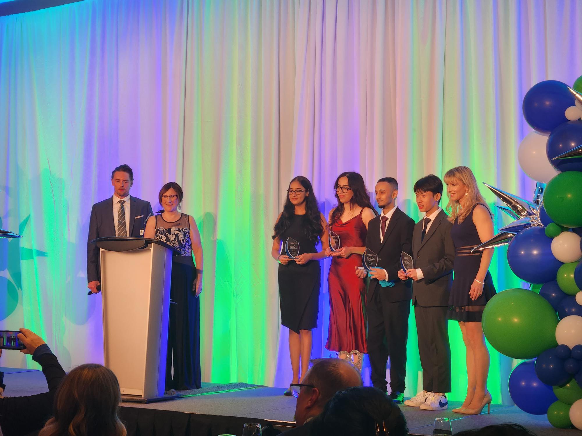 Sheridan Quiz-Bowl Team (Rasleen Kaur Sandhu, Maham Madani, Ayush Padwal and Oliver Nguyen) on stage receiving their award for third place