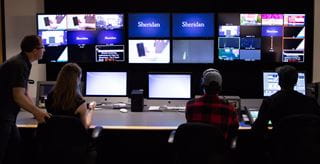 People gathered around a soundboard for a broadcast