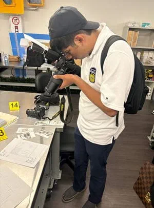 Student Jeremiah Lobo holds a camera and zooms in close.