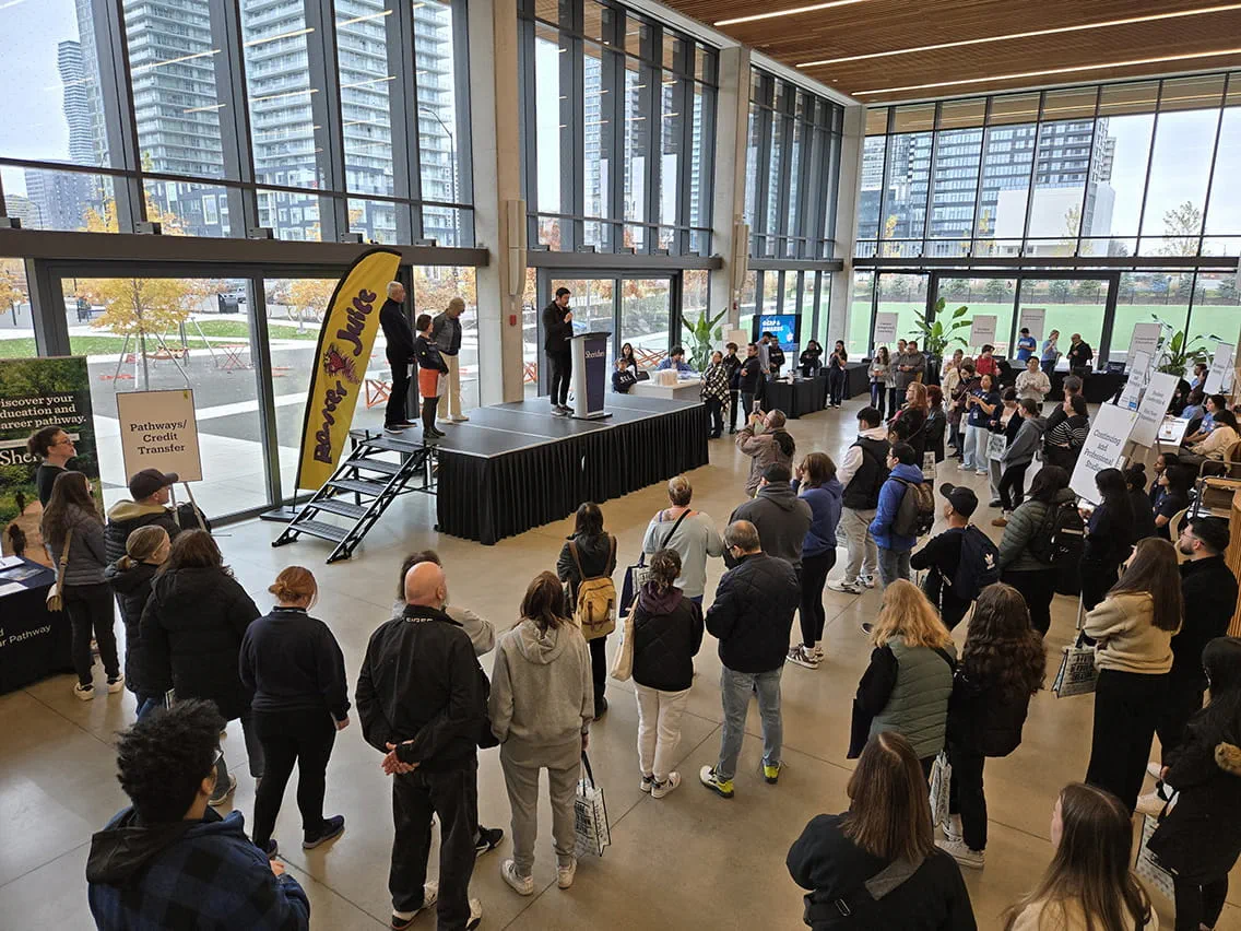 A group of Open House attendees crowded around a stage during the Bruins Welcome Rally