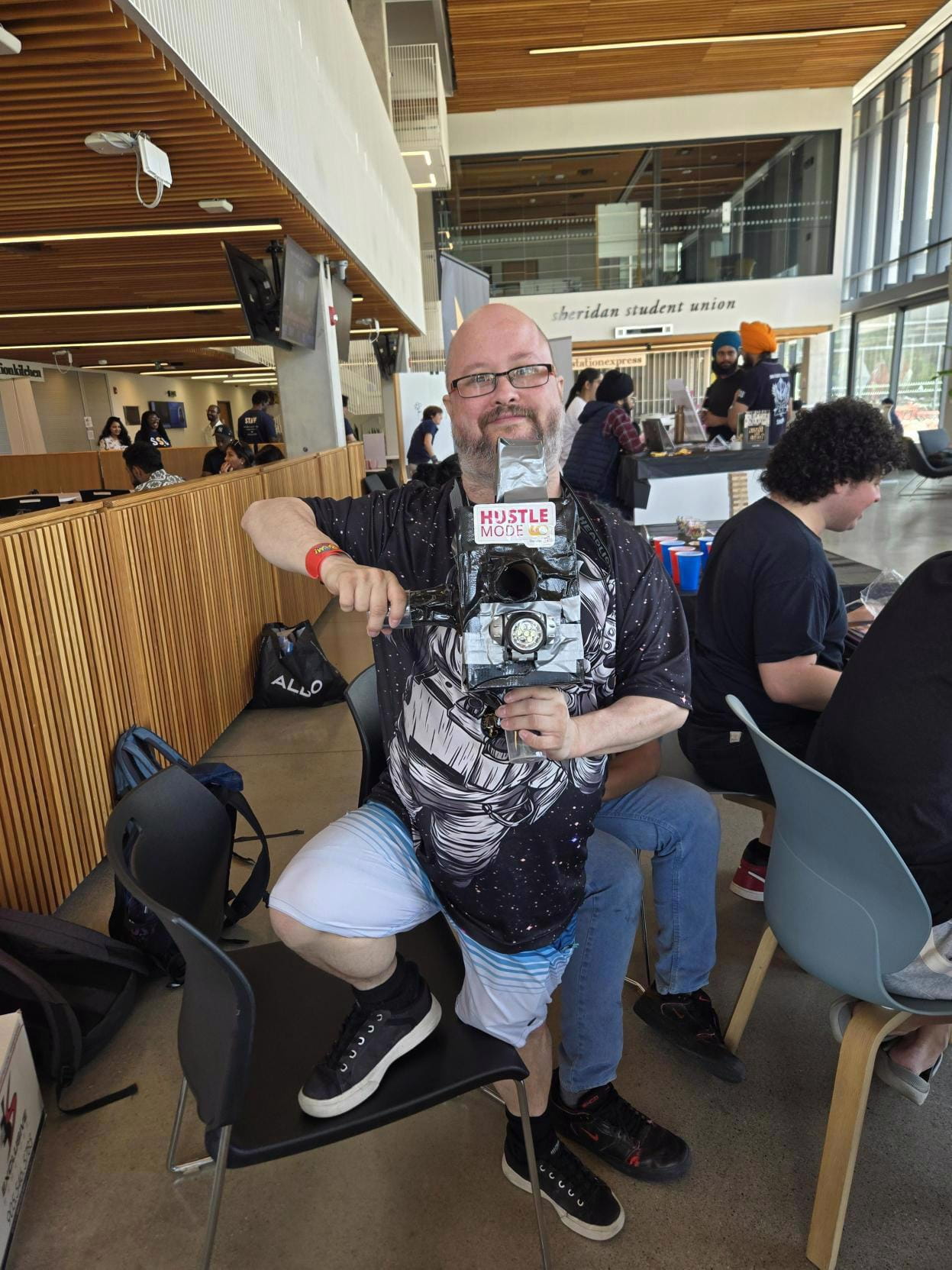 Gregory Lowenthal holding up a video camera while striking a pose.