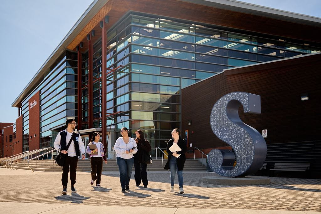 A group of students walk outside Sheridan's Trafalgar Campus in Oakville