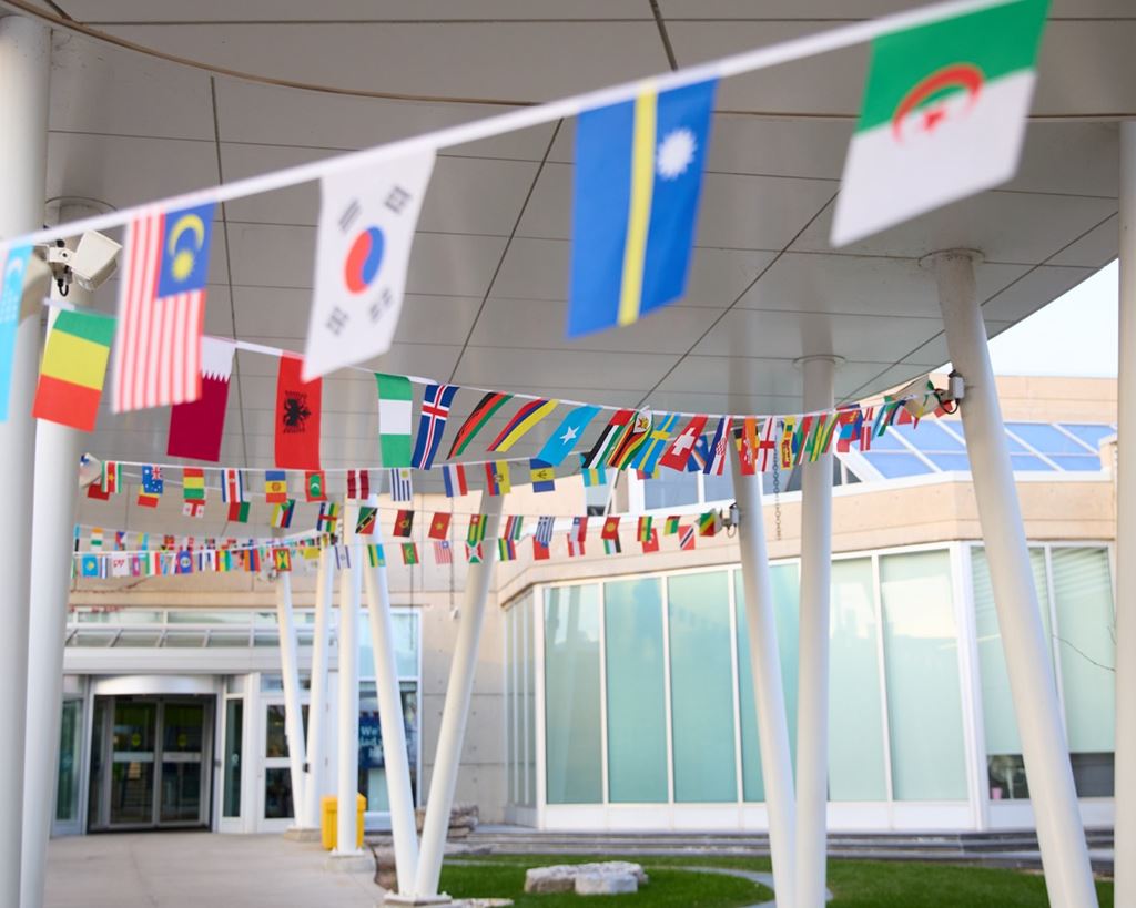 Miniature flags of various countries hang from a ribbon that runs throughout a communal space