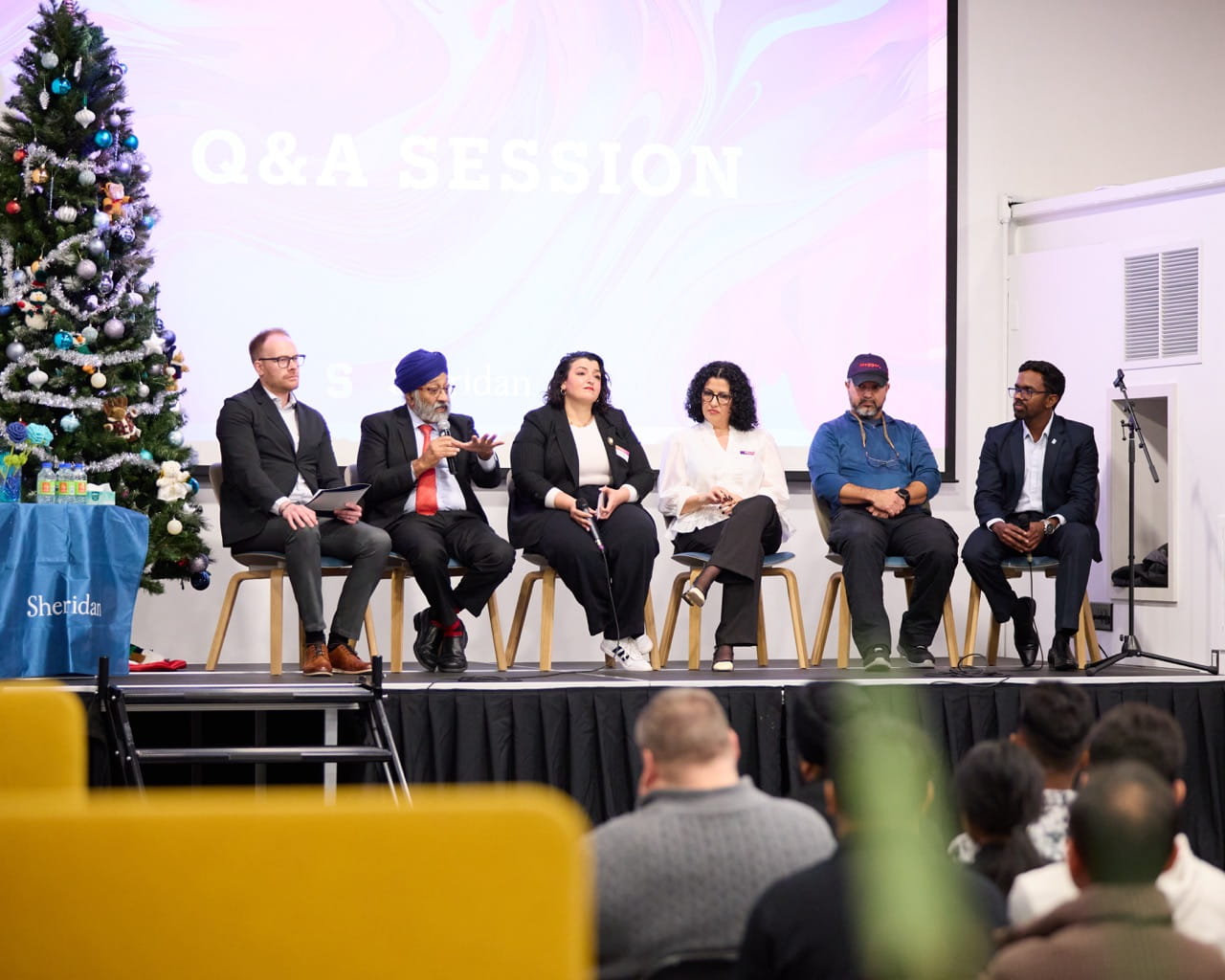 Panelists sit side by side on a stage