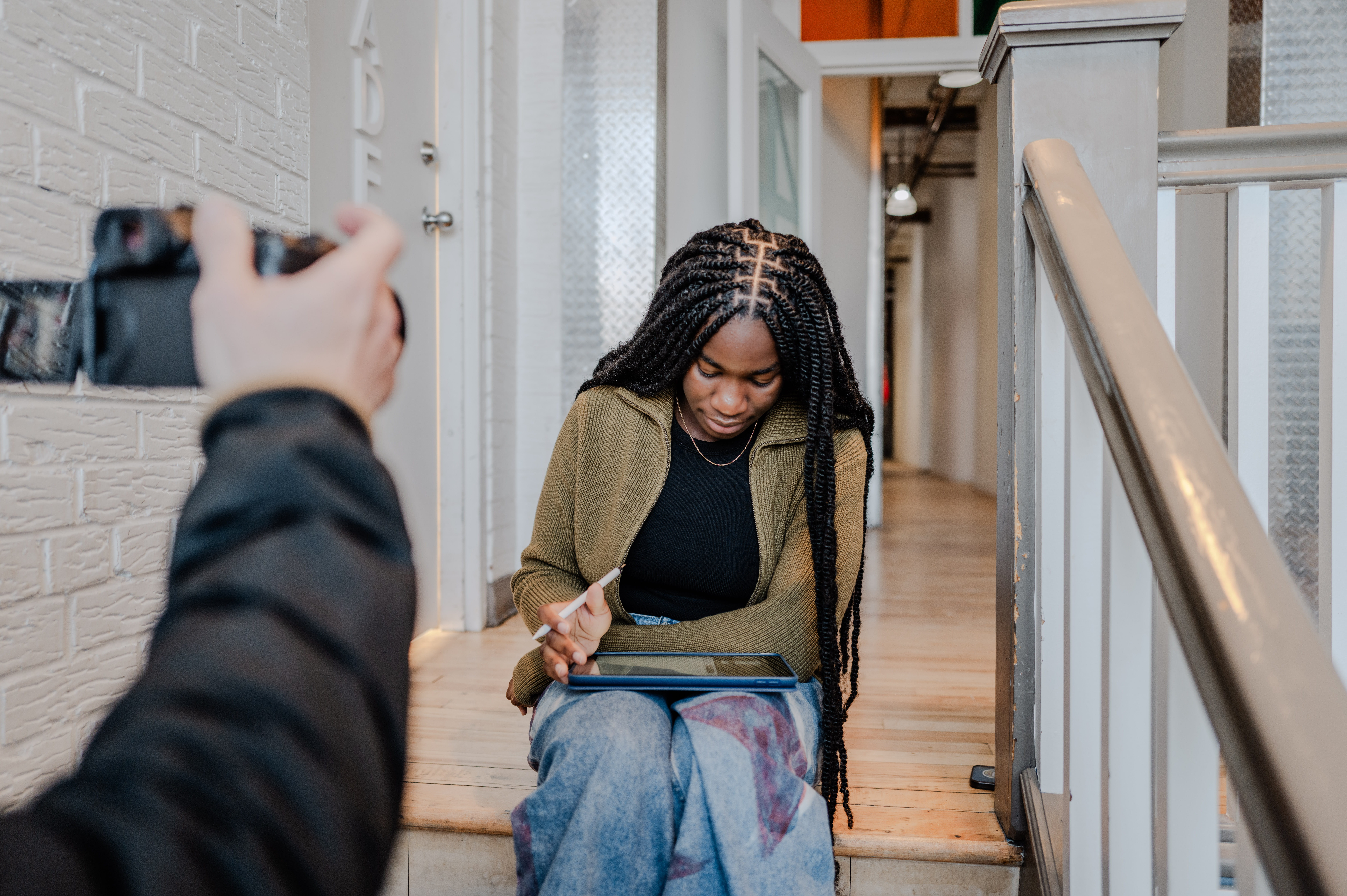 A photo of Rubiat Fusigboye seated and working on a tablet