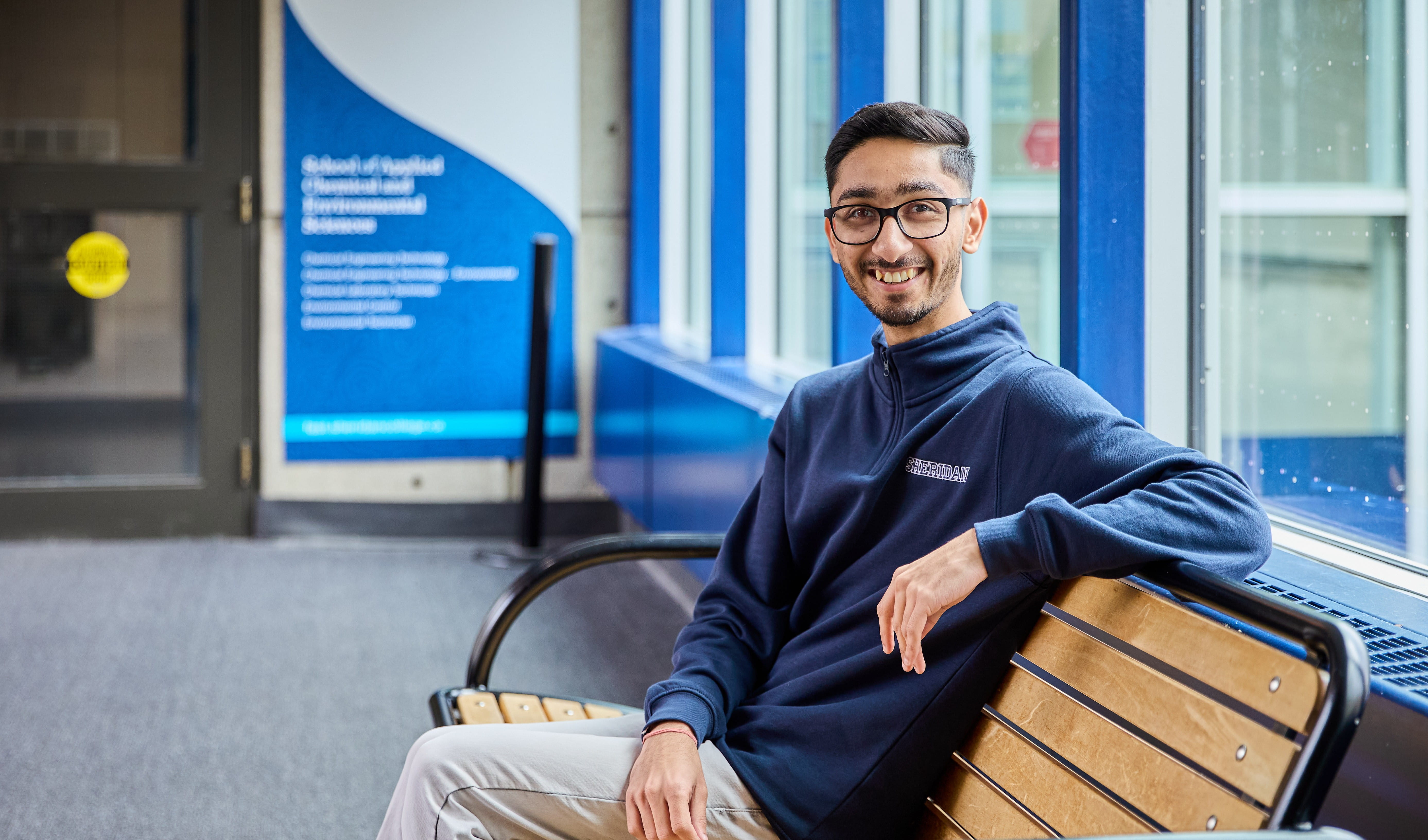 Paras Sharmas is pictured sitting on a bench outside one of Sheridan's offices