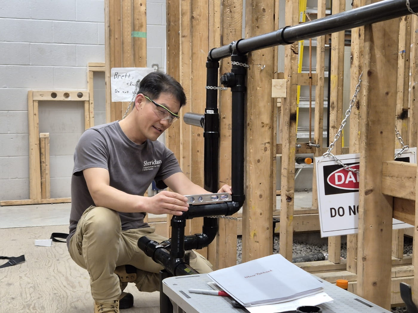 Chulyoung Hur uses a level while completing an exercise in Sheridan's plumbing lab