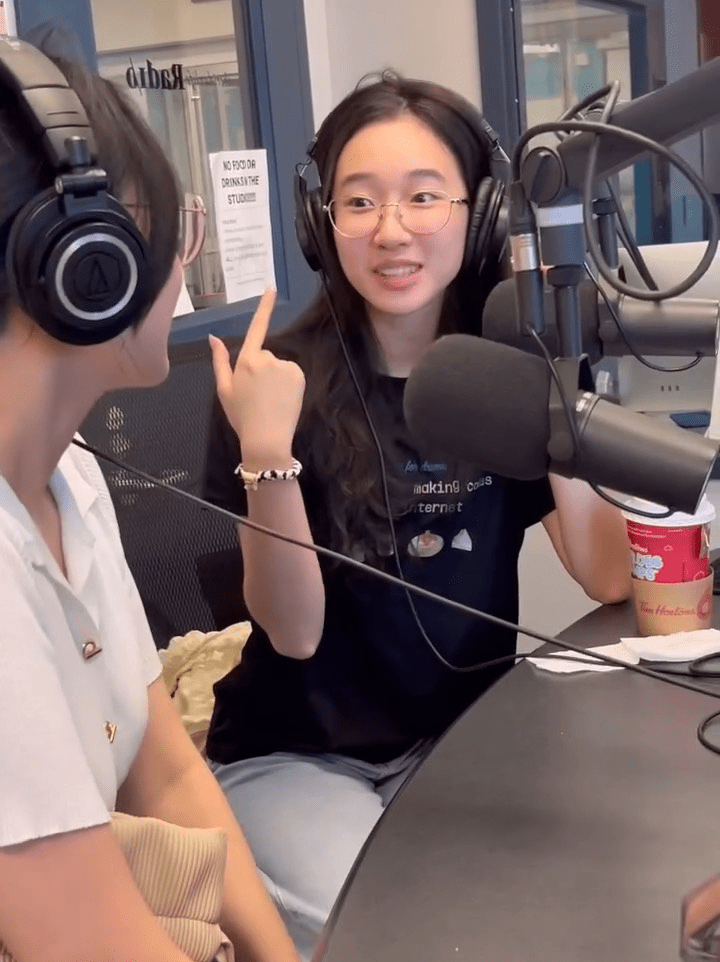Cat Nguyen speaks to a peer while wearing a headset inside a Sheridan recording studio
