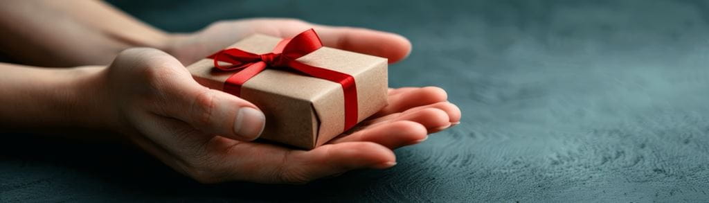 Outreached hands holding a small gift