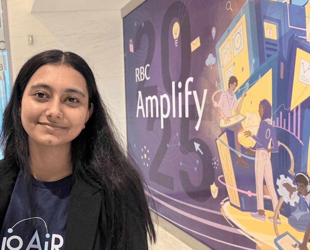Valedictorian Anreet Kaur stands next to a sign that says RBC Amplify.