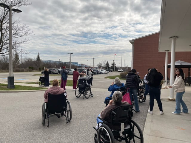 Extendicare residents and staff enjoy watching the solar eclipse outside the facility with Sheridan students and faculty. 