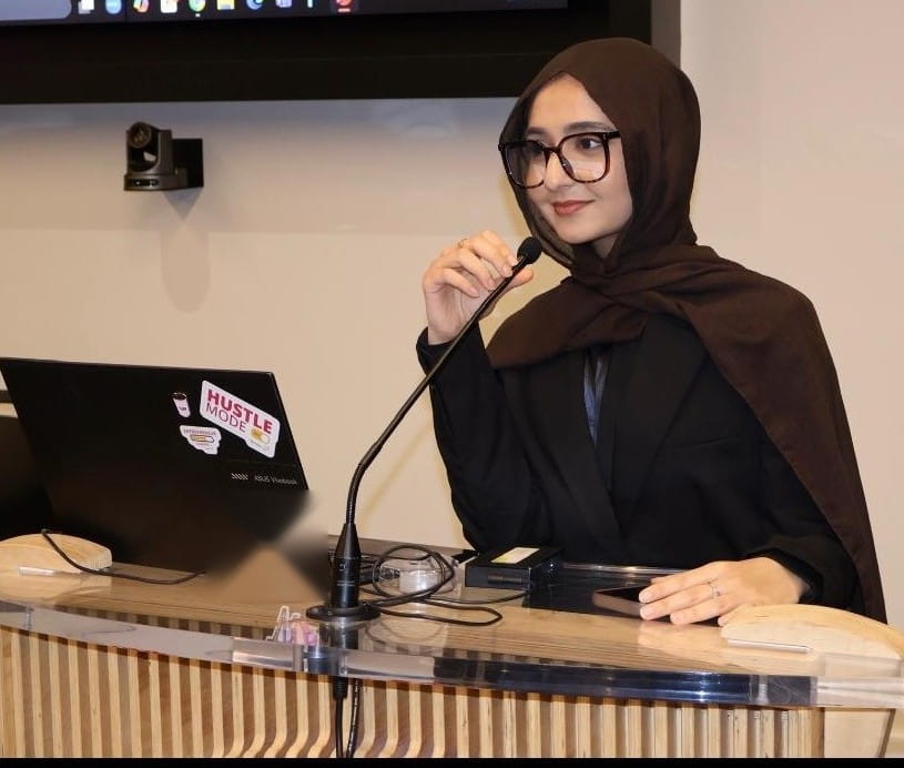 Valedictorian Fiza Kaleem speaks into a microphone at a podium.