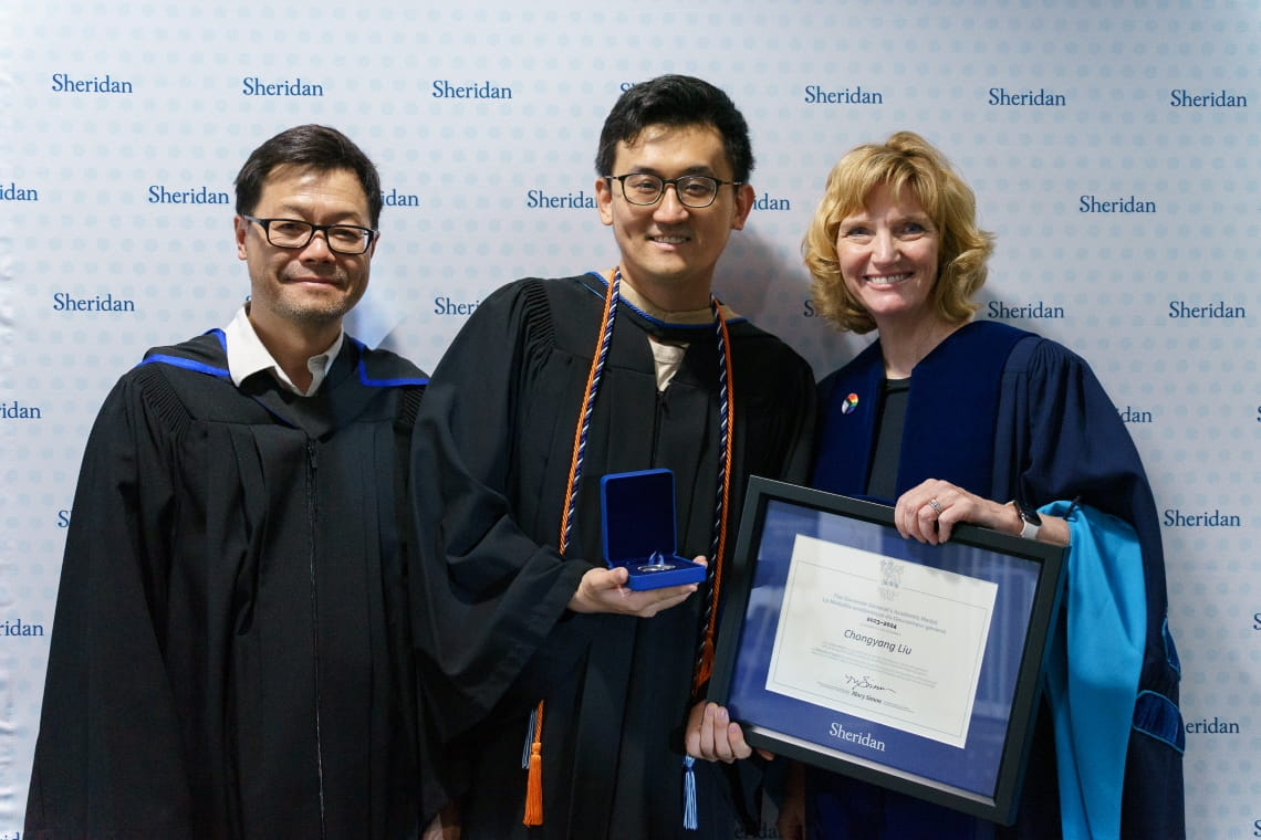 Governor General silver award winner Chongyang Liu poses with a faculty member and President Morrison.