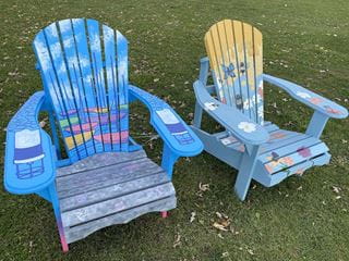 Two colourful Muskoka chairs designed and painted by Sheridan students on display in Bronte Heritage Waterfront Park.