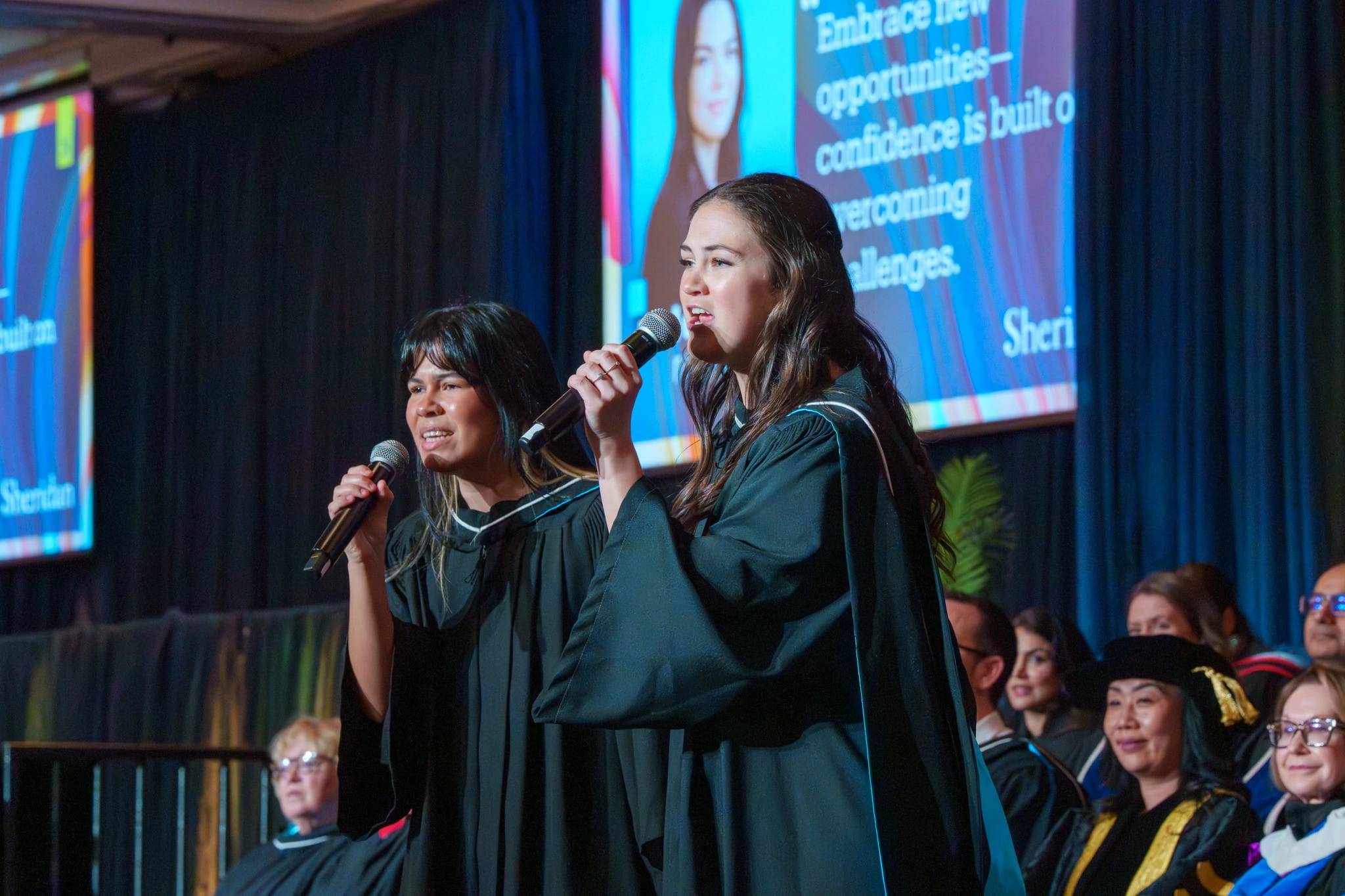 Ariana Bonifaz and Emma Reynolds perform a song on stage.