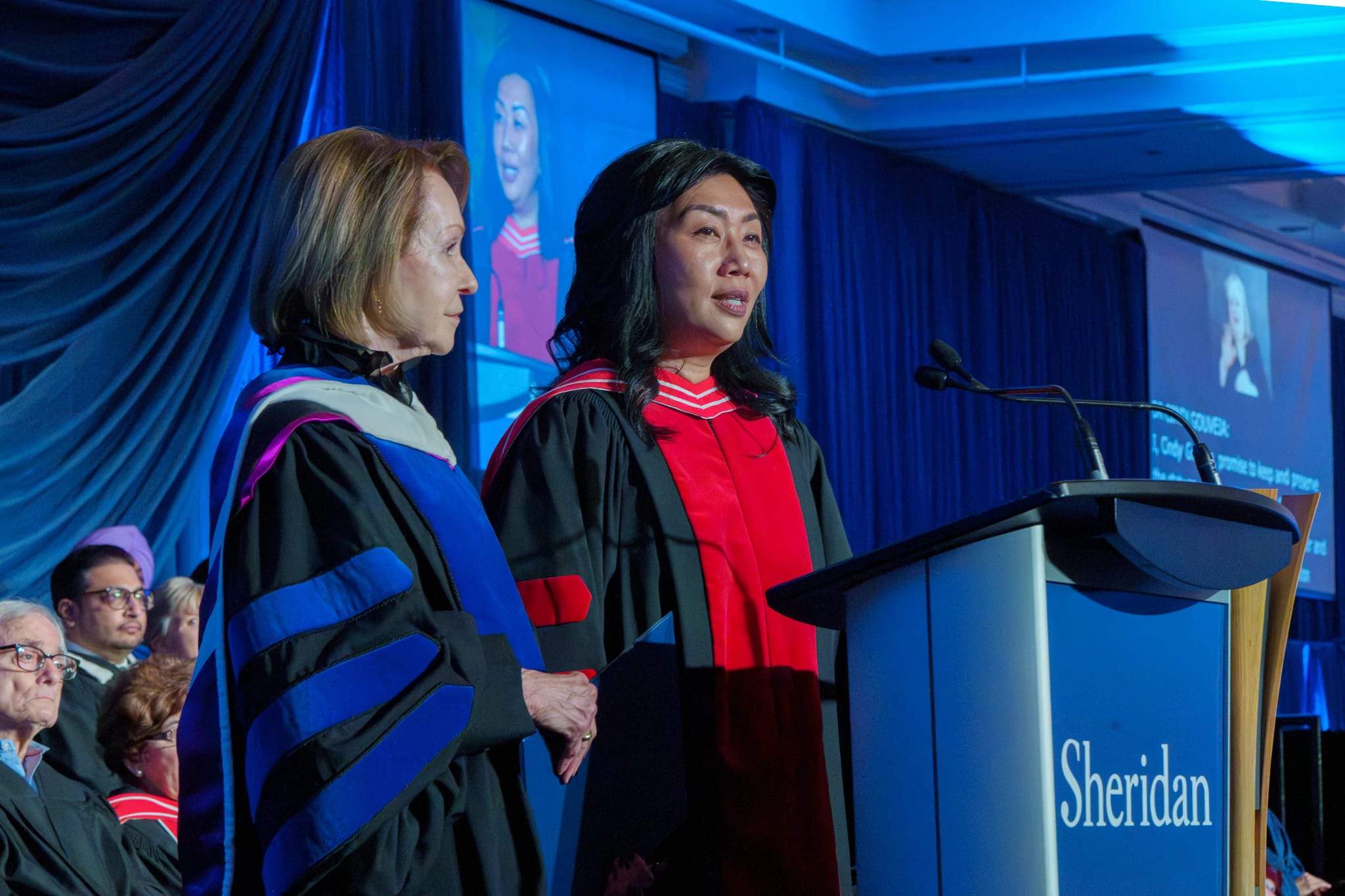 Board Chair Mary E. Hofstetter and Dr. Cindy Gouveia stand together at a podium.