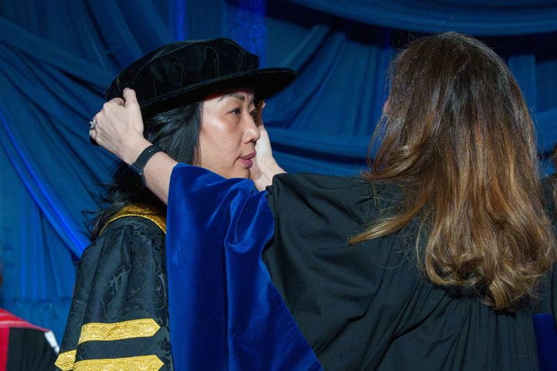 Dr. Sara Cumming performs the changing of the robes for Dr. Cindy Gouveia.