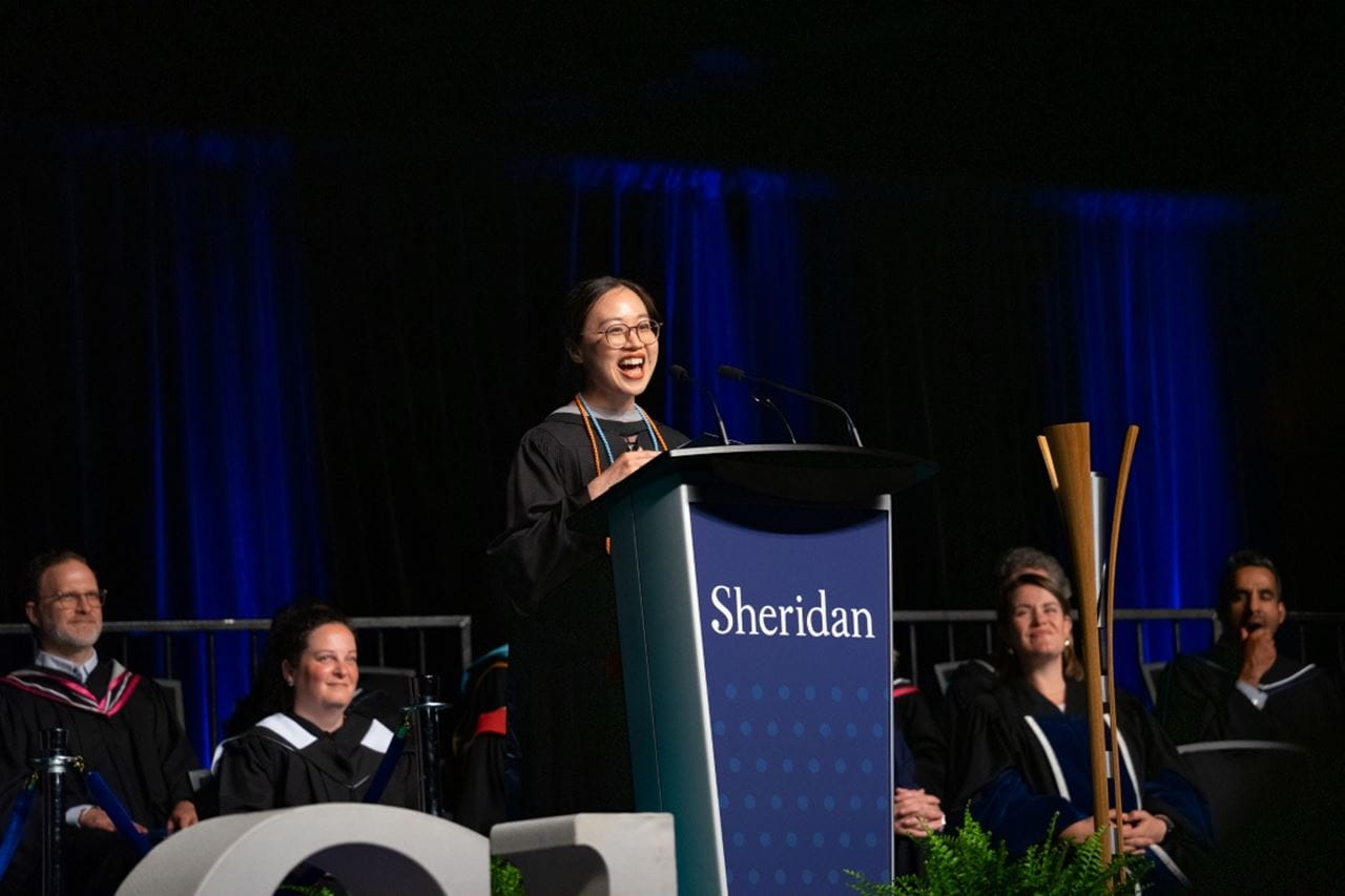 FAAD valedictorian Li Li gives her speech on stage at convocation