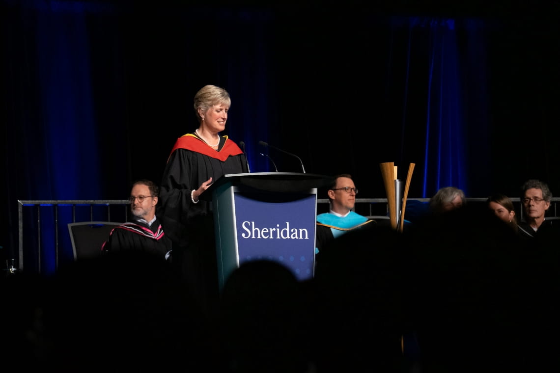 Provost and Vice President Mary Vaughan delivers remarks at the podium as the convocation emcee.