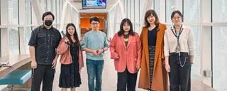 Students standing side-by-side in a hallway.