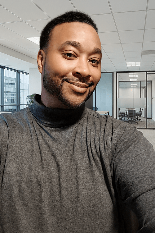 A head and shoulders portrait of Sheridan student Norman Henry standing inside a building
