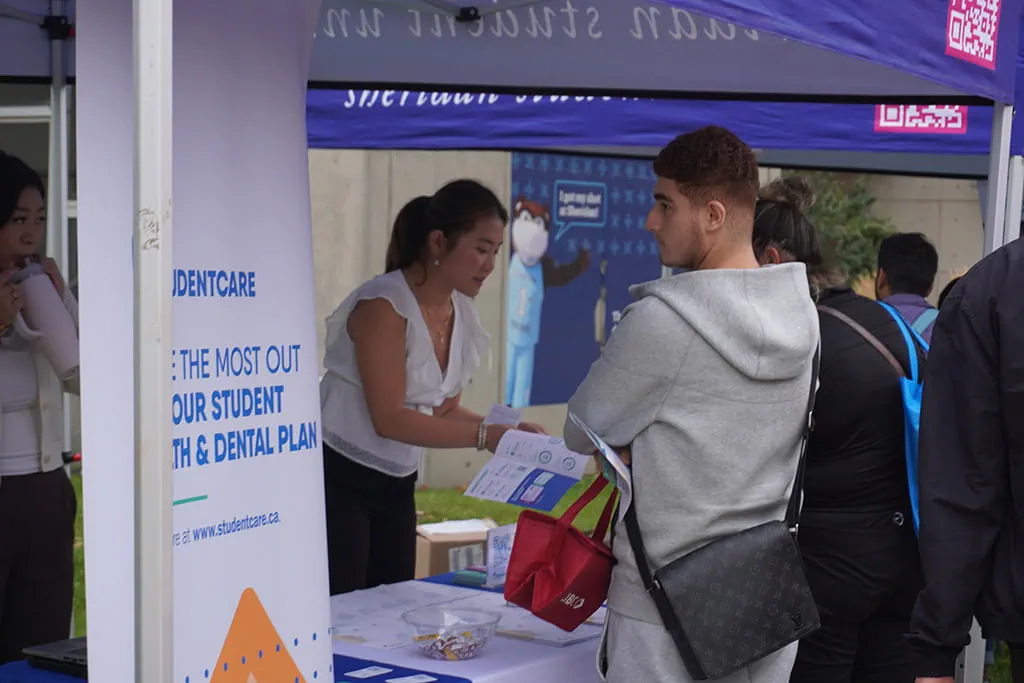 Students at a Sheridan Student Union booth during New Student Orientation