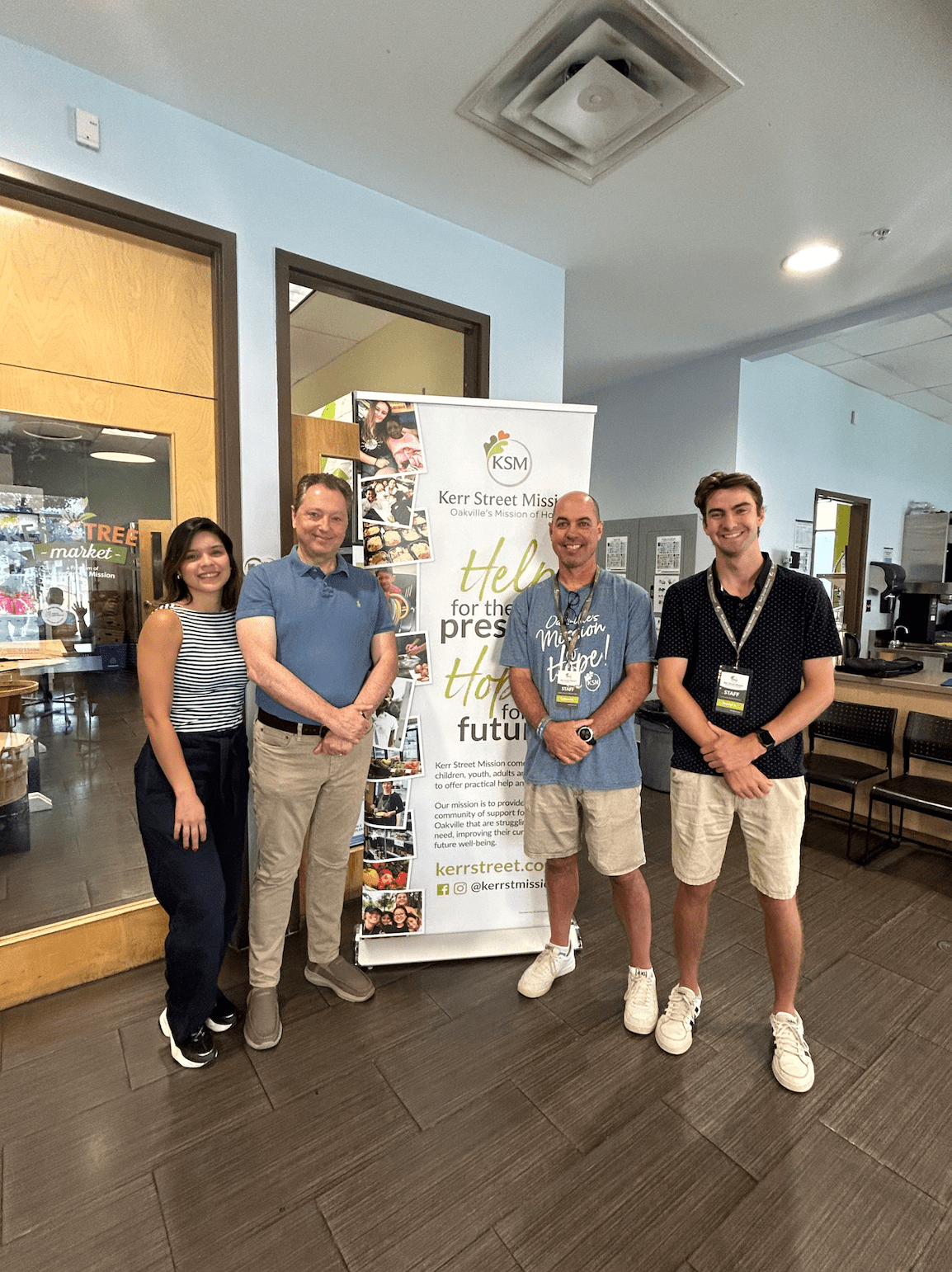 Interior decorating student Gabriela Giron stands inside Kerr Street Mission with Kerr Street Mission project manager Callum McGeorge and two other people.