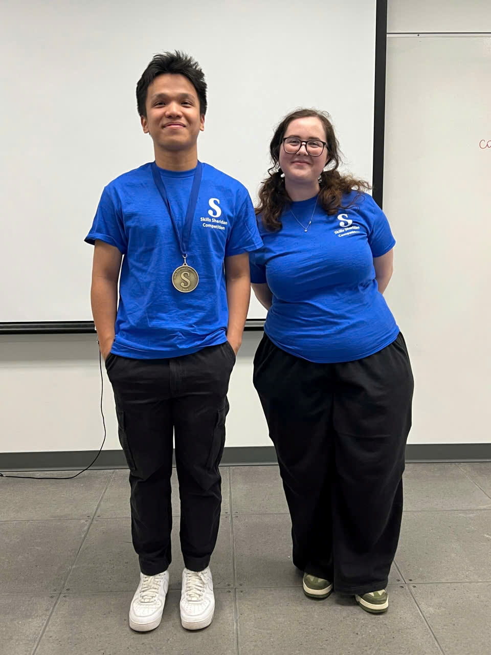Valedictorian Thinh Luu with a classmate, both wearing blue shirts.
