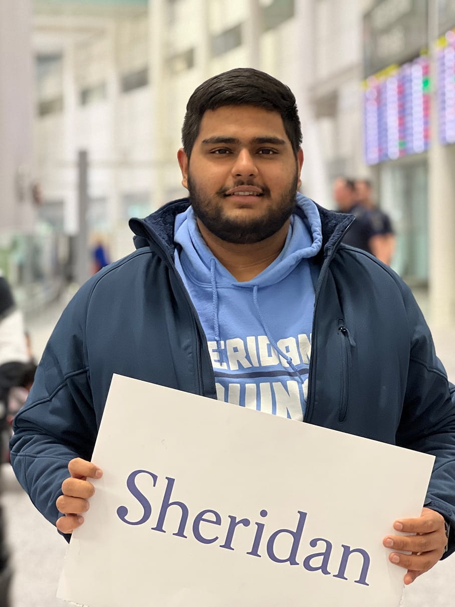 Valedictorian Luvraj Tyagi holds a sign that says Sheridan.