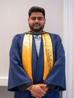 Valedictorian Luvraj Tyagi wears his blue convocation robe and gold valedictorian sash.
