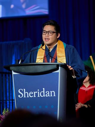 Valedictorian Nathan Sasing gives his speech at a podium.