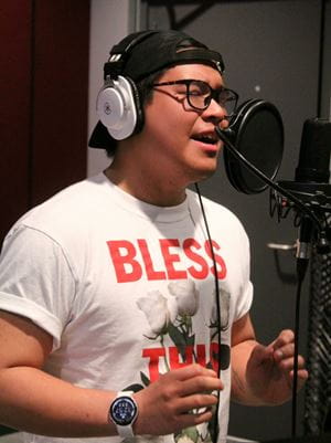 Valedictorian Nathan Josiah Sasing stands at a microphone and sings.