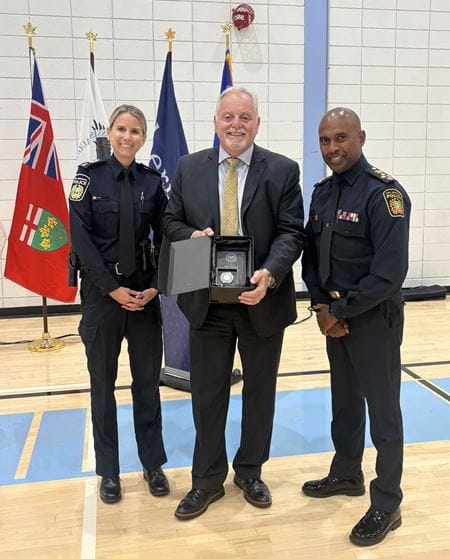 Tara Farrow and Police Chief Nishan Durraipah present an award to Lee Weare.