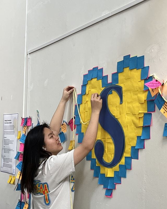 Zhilin Guo adds finishing touches to her interactive art display Making Connections: From Home to Sheridan