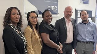 Five people posing side-by-side under a 'CIBC' wall plaque.