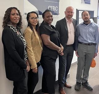 Five people posing side-by-side under a 'CIBC' wall plaque.
