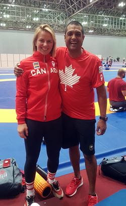 Alumnus Surinder Budwal standing with 2016 Olympic gold medalist Erica Wiebe at the Tokyo Olympics.