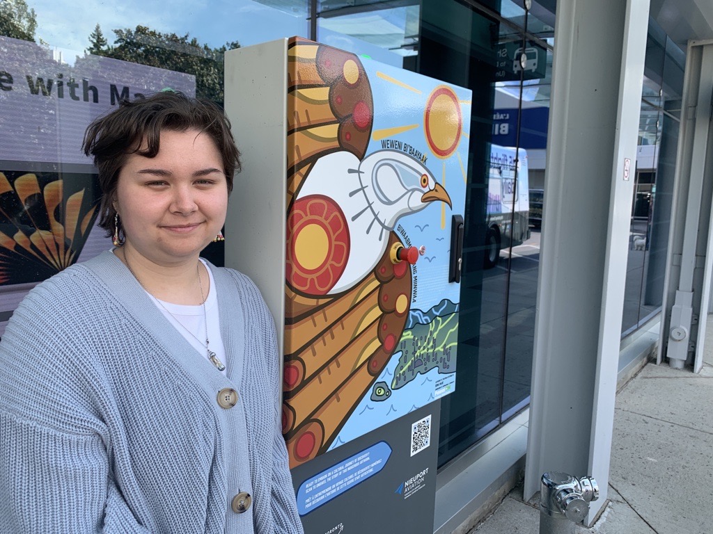 roma poses in front of artwork