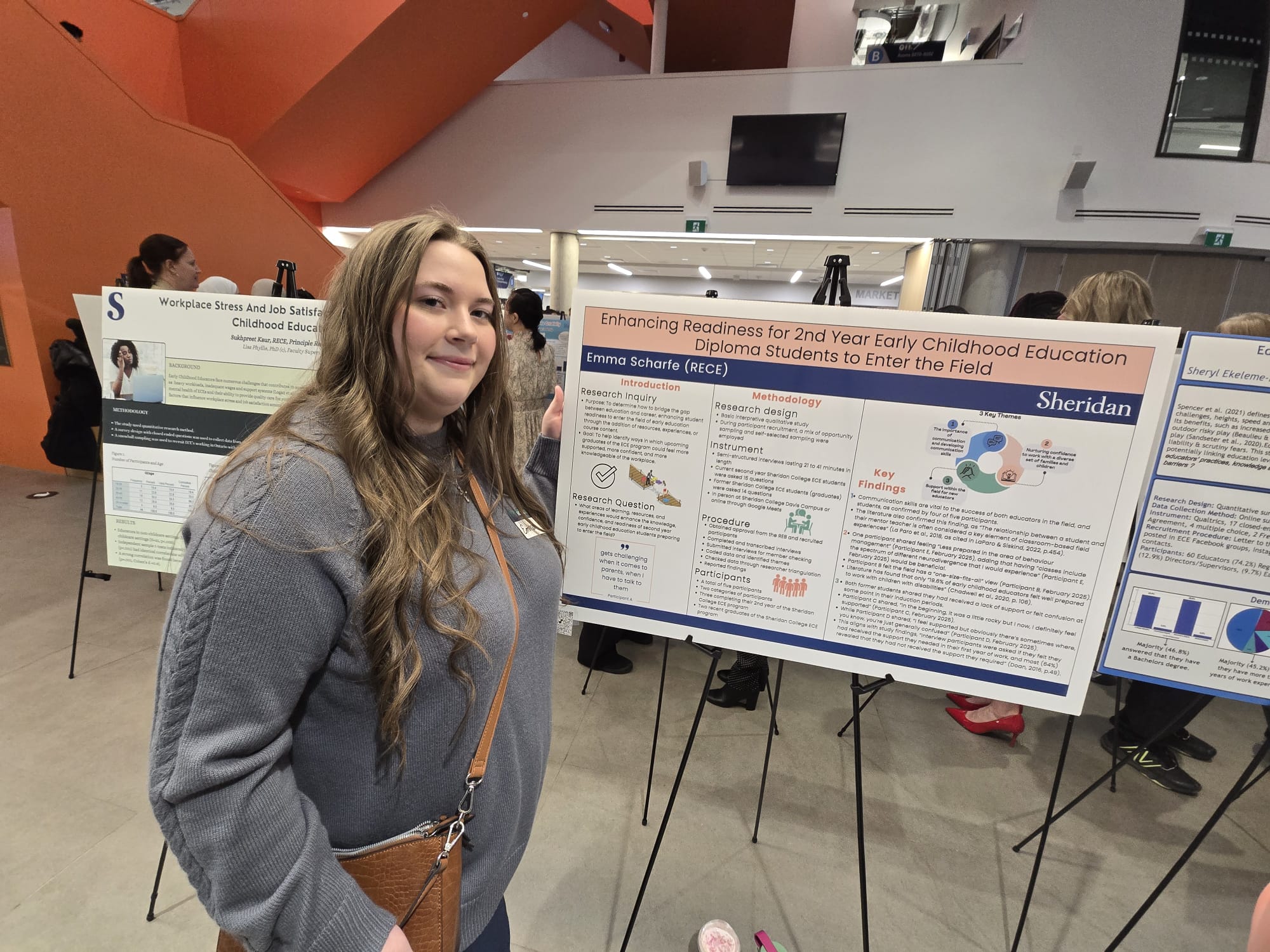 Student Emma Scharfe is pictured beside a poster for her capstone project Enhancing Readiness for 2nd Year Early Childhood Education Diploma Students to Enter the Field