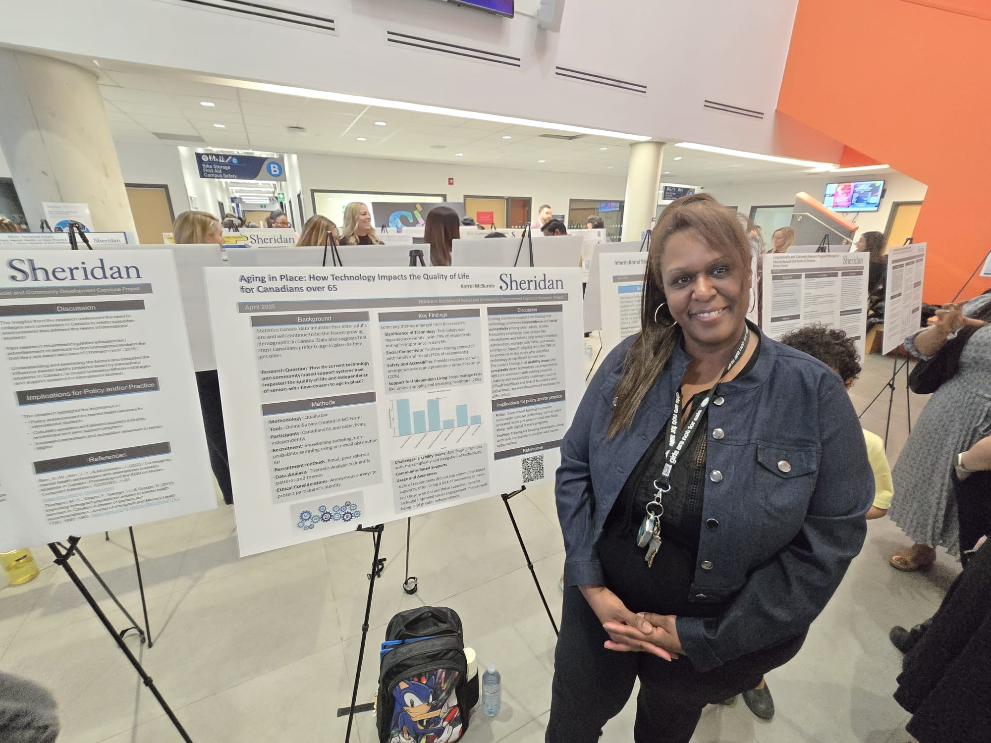 Student Karrol McBurnie is pictured with a poster for her capstone project Aging in Place: How Technology Impacts the Quality of Life for Canadians over 65