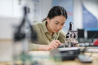 A student researcher examines an electronic device