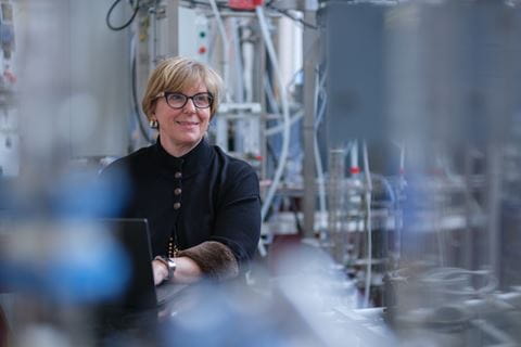 Sheridan professor and program coordinator Anita Usas Neving seated in front of a laptop inside a lab environment.