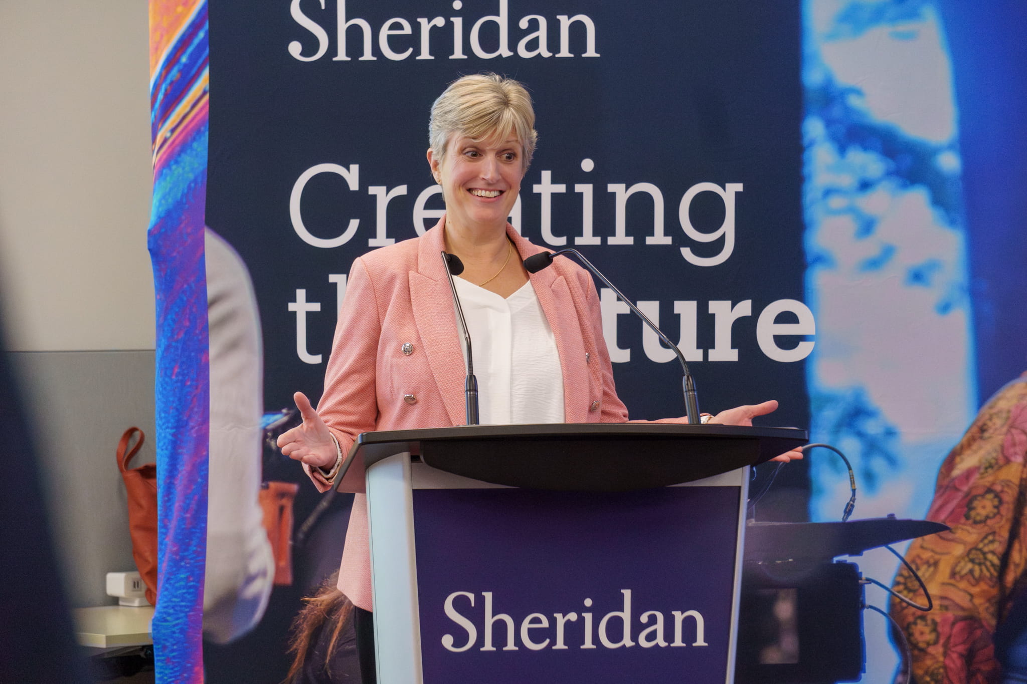 Sheridan Provost and Vice President, Academic, Mary Vaughan stands behind a podium delivering remarks