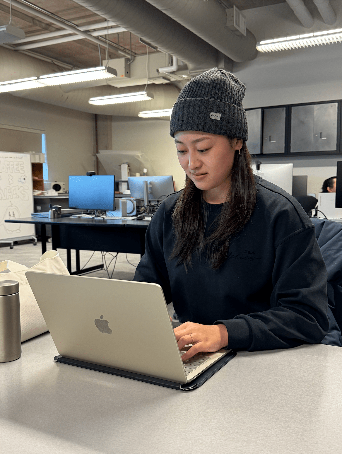 Sheridan student Yuke Yi is pictured sitting at a desk working on a laptop