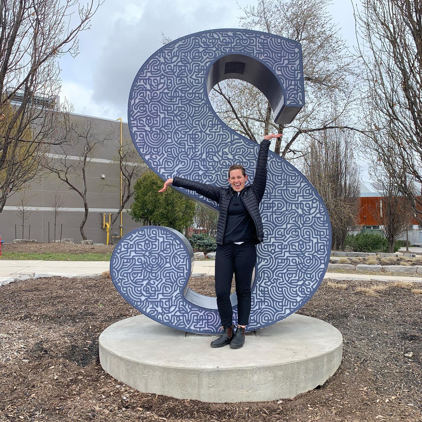 Eleanor Miller stands in front of Sheridan "S" on campus