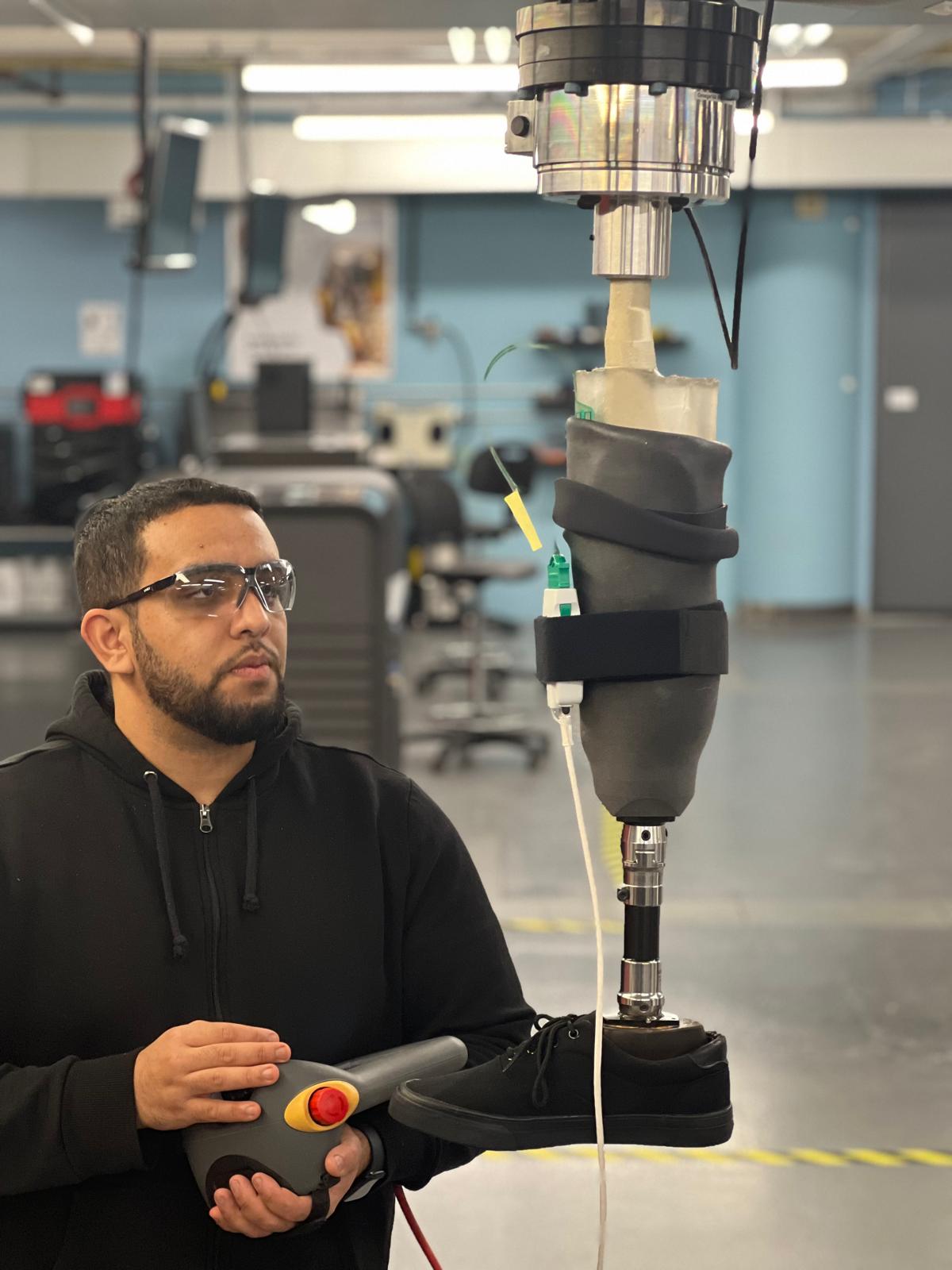 Mechanical Engineering student Mohamed Kasim operates an industrial robot to mimic a person's walking motion